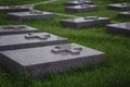 Gray marble tombstones with crosses on a green lawn in a cemetery. Memory and sorrow
