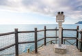 Gray metal binocular stands on a raised platform overlooking the sea Royalty Free Stock Photo