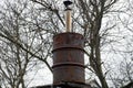 Gray metal chimney pipe on a brown old iron barrel Royalty Free Stock Photo