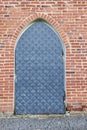 Gray metal door, red brick wall, pavement of gray stone Royalty Free Stock Photo