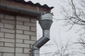 Gray metal drainpipe on a white brick wall Royalty Free Stock Photo
