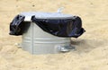 Gray metal garbage bin or can on beach Royalty Free Stock Photo
