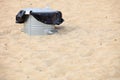 Gray metal garbage bin or can on beach Royalty Free Stock Photo