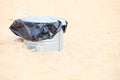 Gray metal garbage bin or can on beach Royalty Free Stock Photo