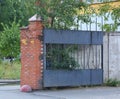 Gray metal gate in a brick-concrete fence Royalty Free Stock Photo