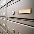 Gray metal mailboxes with name badges close-up.