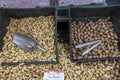 A gray metal scoop in a black basket filled with raw peanuts at a market in Atlanta Georgia