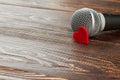 Gray microphone on dark wooden background.