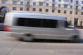 A gray minibus down with a blur in motion