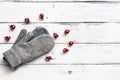 Gray mittens and red Christmas toys on a white rustic wooden board background. Top view, flat lay, copy space Royalty Free Stock Photo