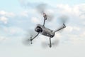 gray modern quadcopter is flying against the blue sky. Royalty Free Stock Photo