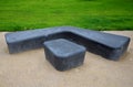 Gray monolithic concrete park bench made of concrete in the shape of round stones anthracite color park paths and interlocking pav Royalty Free Stock Photo