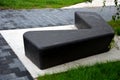 Gray monolithic concrete park bench made of concrete in the shape of round stones anthracite color park paths and interlocking pav Royalty Free Stock Photo