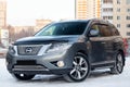 Gray Nissan Pathfinder 2015 year front view with dark black interior in excellent condition in a parking space with snow