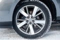 Gray Nissan Pathfinder 2015 year front wheel view with dark black interior in excellent condition in a parking space with snow