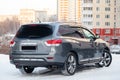 Gray Nissan Pathfinder 2015 year rear view with dark black interior in excellent condition in a parking space with snow background