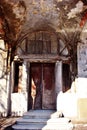 Gray old castle ruined walls and door with columns on sides, steps with bright sunlight Royalty Free Stock Photo