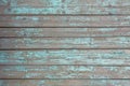 Gray old fence wall of wooden planks with blue turquoise peeling paint and cracks. horizontal lines. rough surface texture Royalty Free Stock Photo