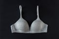 Gray organic or recycled cotton bra on black background, top view, copy space, flat lay. Concept of femininity, comfort, home