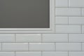 Gray painted wall, part of the wall is covered tiles small white glossy brick, ceramic decorative molding tiles, detail of intrica Royalty Free Stock Photo