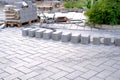 Gray paving blocks on the ballast, side view, construction site of pavement modern granite cobblestone road in city center, Royalty Free Stock Photo