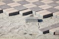 Gray paving blocks - side view. New sidewalk with rectangular stones on sandy ballast. Paving tiles in the process of laying Royalty Free Stock Photo