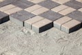 Gray paving blocks - side view. New sidewalk with rectangular stones. Paving tiles in the process of laying Royalty Free Stock Photo