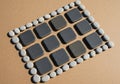 Gray pebbles and black stones arranged on a sandy brown surface. Royalty Free Stock Photo