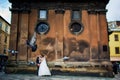 Gray pigeons in flight, in the background wedding couple in love at old church Royalty Free Stock Photo