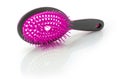 Hairbrush with plastic bristles on a white reflective surface
