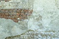 Gray plastered old brickwall with chipped stucco pieces. Grunge red and white brick wall with damaged surface background Royalty Free Stock Photo