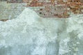 Gray plastered old brickwall with chipped stucco pieces. Grunge red and white brick wall with damaged surface background Royalty Free Stock Photo