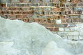 Gray plastered old brickwall with chipped stucco pieces. Grunge red and white brick wall with damaged surface background Royalty Free Stock Photo