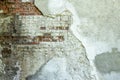 Gray plastered old brickwall with chipped stucco pieces. Grunge red and white brick wall with damaged surface background Royalty Free Stock Photo