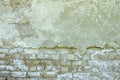 Gray plastered old brickwall with chipped stucco pieces. Grunge white brick wall with damaged surface background Royalty Free Stock Photo