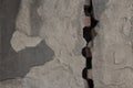 Gray plastered wall divided by wide crack. Rough texture Royalty Free Stock Photo