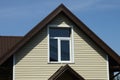 Gray plastic attic of a private rural house with one window under a brown tiled roof Royalty Free Stock Photo