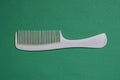 gray plastic comb lies on a green table Royalty Free Stock Photo