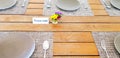 Gray Plate with spoon and fork putting on wooden table for customers to eating food and reserved with beautiful flower Royalty Free Stock Photo