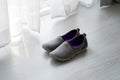 Gray, purple fabric shoes beside view