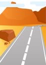 A gray roadbed goes along an orange hill next to large stones and mountains in the distance Royalty Free Stock Photo