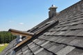 A gray roof covered with dimensional architectural asphalt shingles with an attic skylight, ventilation pipe, air duct and chimney Royalty Free Stock Photo