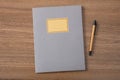 Grey school notebook or diary, old fashioned, on wooden desk, blank label, space for text, top view