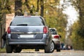 Gray shiny car parked in quiet area on asphalt road on blurred bokeh background on bright sunny day. Transportation and parking Royalty Free Stock Photo