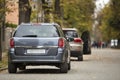 Gray shiny car parked in quiet area on asphalt road on blurred bokeh background on bright sunny day. Transportation and parking Royalty Free Stock Photo