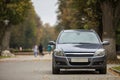 Gray shiny car parked in quiet area on asphalt road on blurred bokeh background on bright sunny day. Transportation and parking Royalty Free Stock Photo