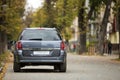 Gray shiny car parked in quiet area on asphalt road on blurred bokeh background on bright sunny day. Transportation and parking Royalty Free Stock Photo