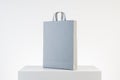 Gray shoping bag with handles on concrete podium