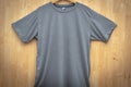 Minimalist Chic: Gray Short Sleeve T-Shirt Mockup on Wooden Background