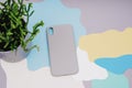 The gray silicone case for the smartphone lies on an abstract background